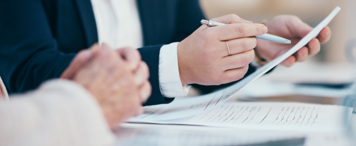 person holding up a pen and paper