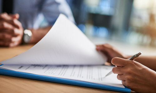 two people reviewing documents at a desk