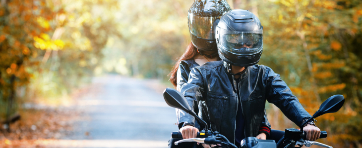 a man and woman on a motorcycle, both wearing helmets