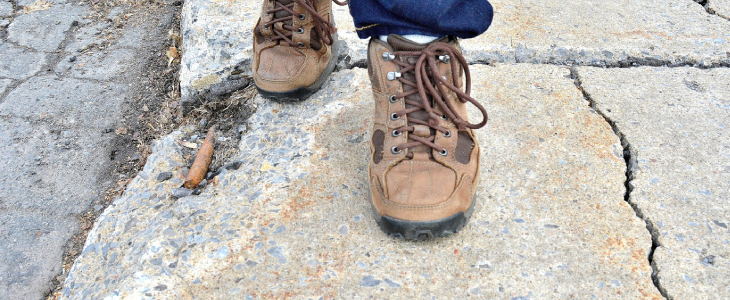 shoes walking on a cracked sidewalk