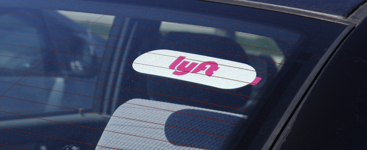 A ridesharing car with a Lyft stick on the windshield