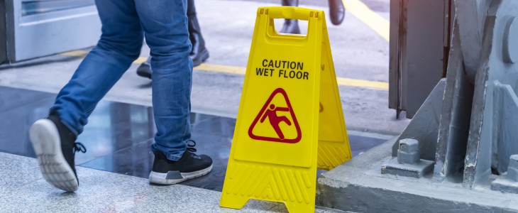 Caution wet floor sign next to a man