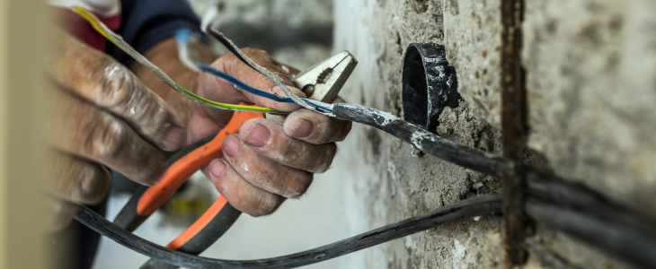 Construction worker cutting wires on a site