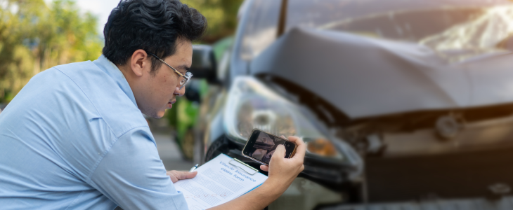 Insurance adjustor taking pictures of a car