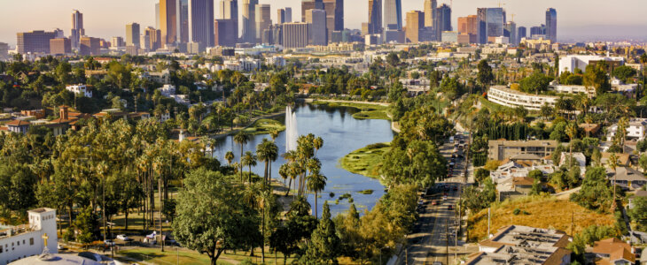 Aerial view of Echo Park Lake surrounded by neighbourhood with high rise office buildings in background, City Of Los Angeles, California, USA.